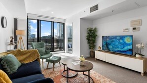 A modern living room with a sofa, armchairs, a coffee table, and a large painting on the wall. - The Luxury/ City Central/ Pool/ Gym/ Parking /WiFi (Adelaide)
