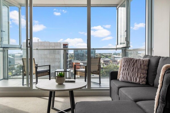 Enjoy a comfortable seating area on the balcony with a sofa, chairs, and a small table.