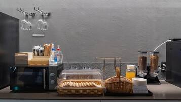 A breakfast bar with bread, pastries, and condiments.