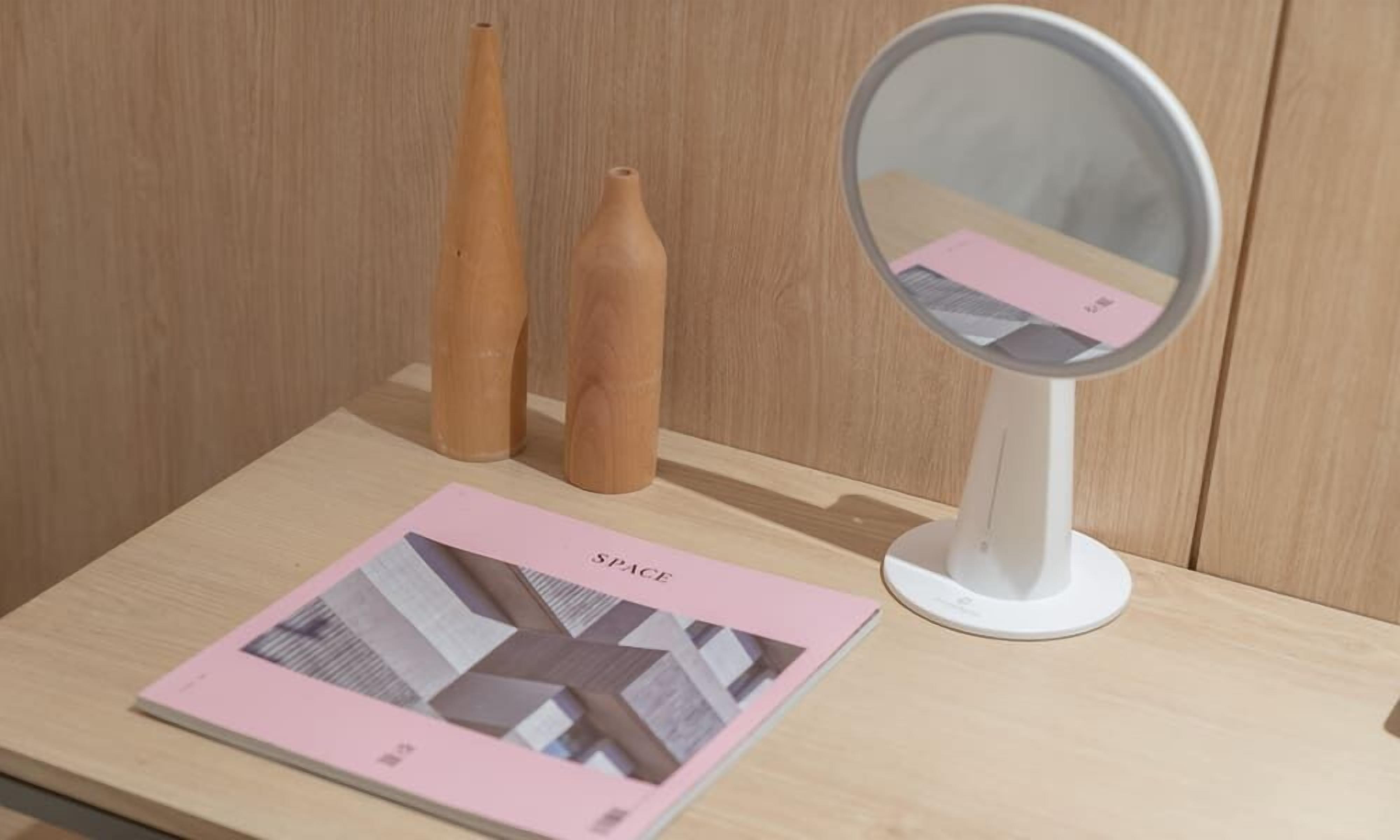A wooden table with a magazine titled "SPACE" and two wooden vases.