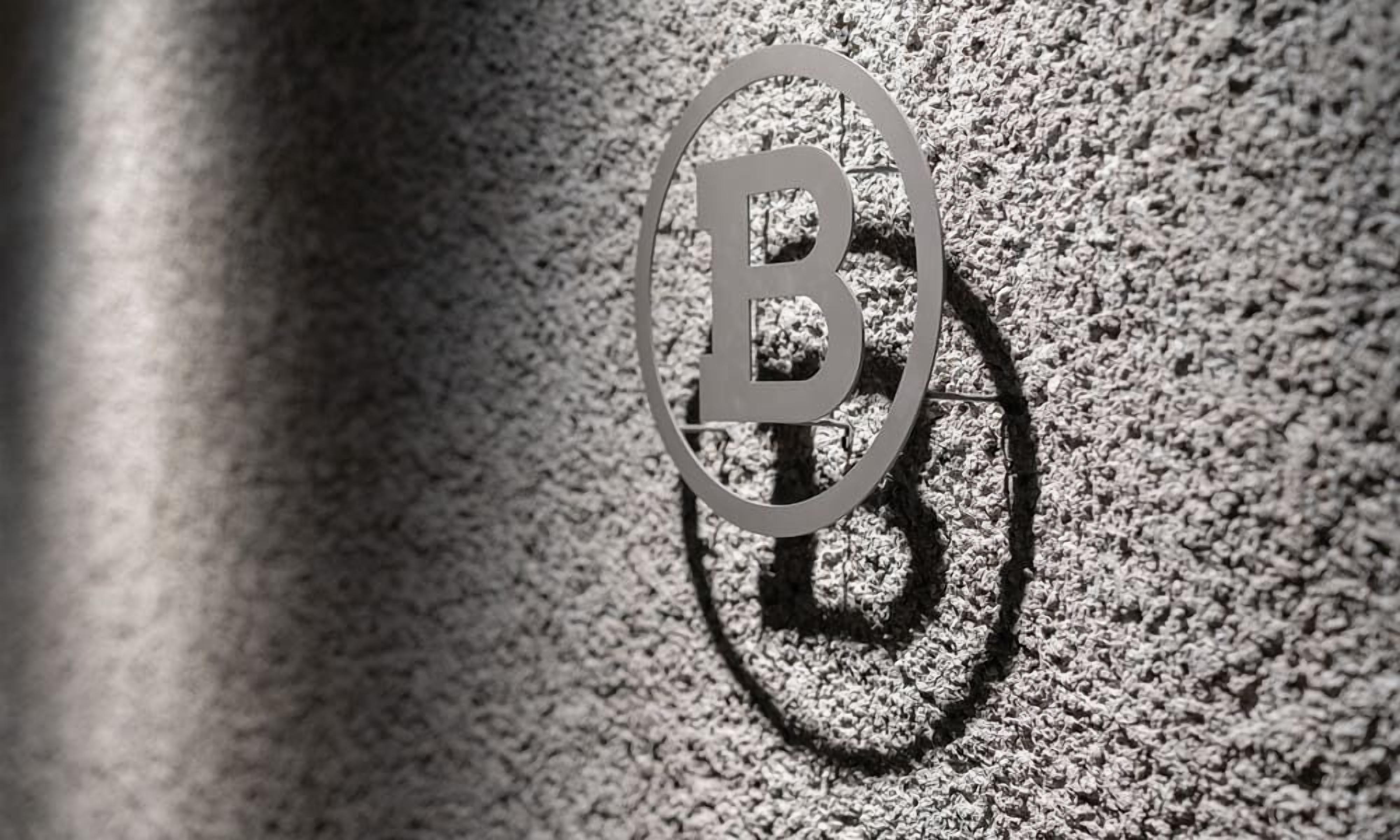 A close-up of a textured surface with a shadow of a letter 'B' cast on it.