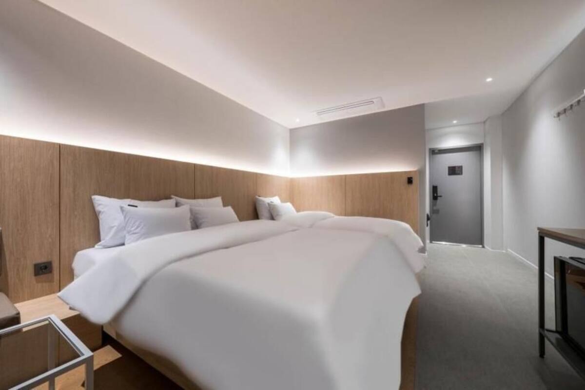 Een moderne hotelkamer met een groot bed, een nachtkastje en een klein bureau.