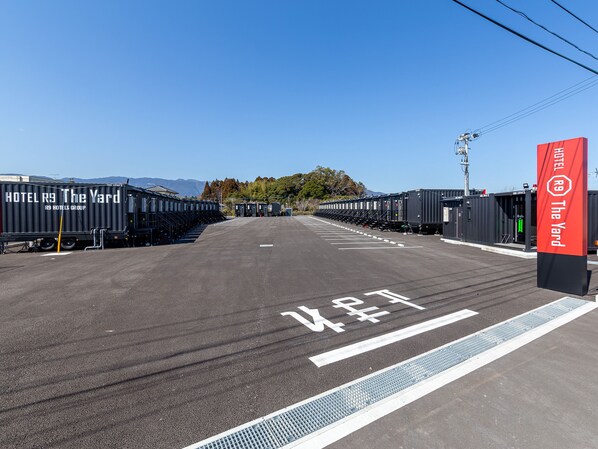 Un estacionamiento con hileras de vehículos recreativos y un letrero rojo para R9 Hotels Group.
