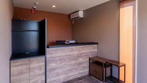 A compact kitchen with a built-in stove, a small sink, and a wooden cabinet. - HOTEL R9 The Yard Kawaminami (Kawaminami)