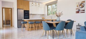 A modern kitchen with a central island, wooden cabinets, and a built-in oven. - Fence off , surrounded by large olive grove 200m from the sandy beach (Ζάκυνθος)
