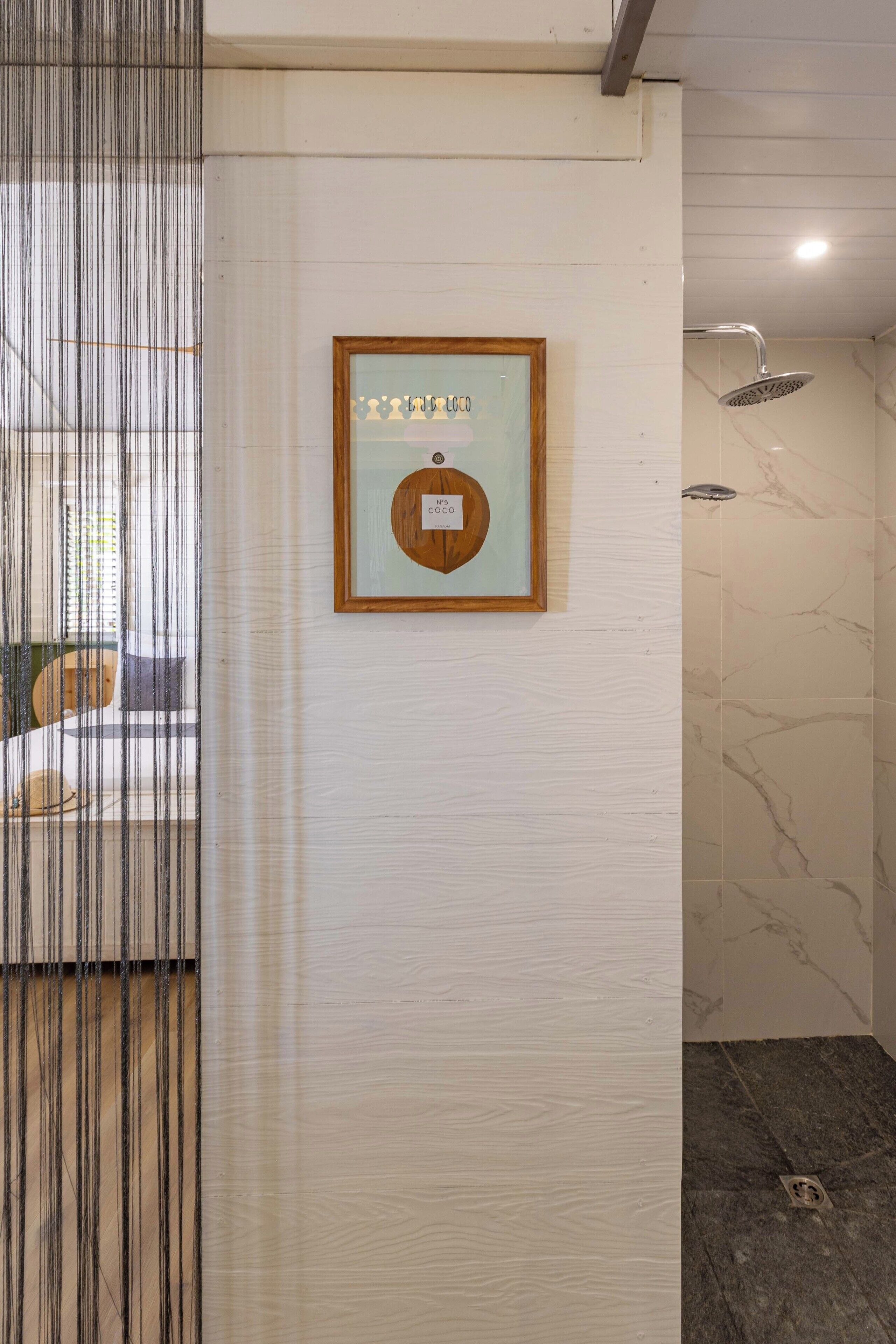 Un certificat encadré accroché au mur, un espace douche avec un mur en marbre et une fenêtre équipée de stores verticaux.