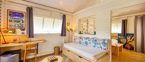 A cozy room with a wooden bed, a desk, and a small table.