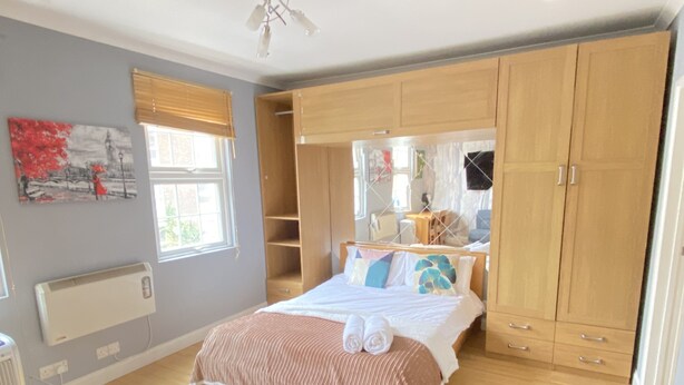 Ein Schlafzimmer mit einem Bett, einem Holzschrank und einer Heizung.