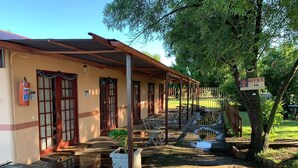 A building with a covered porch, a fire extinguisher, and a sign indicating an office. - Eden Guest Farm (Bloemfontein)