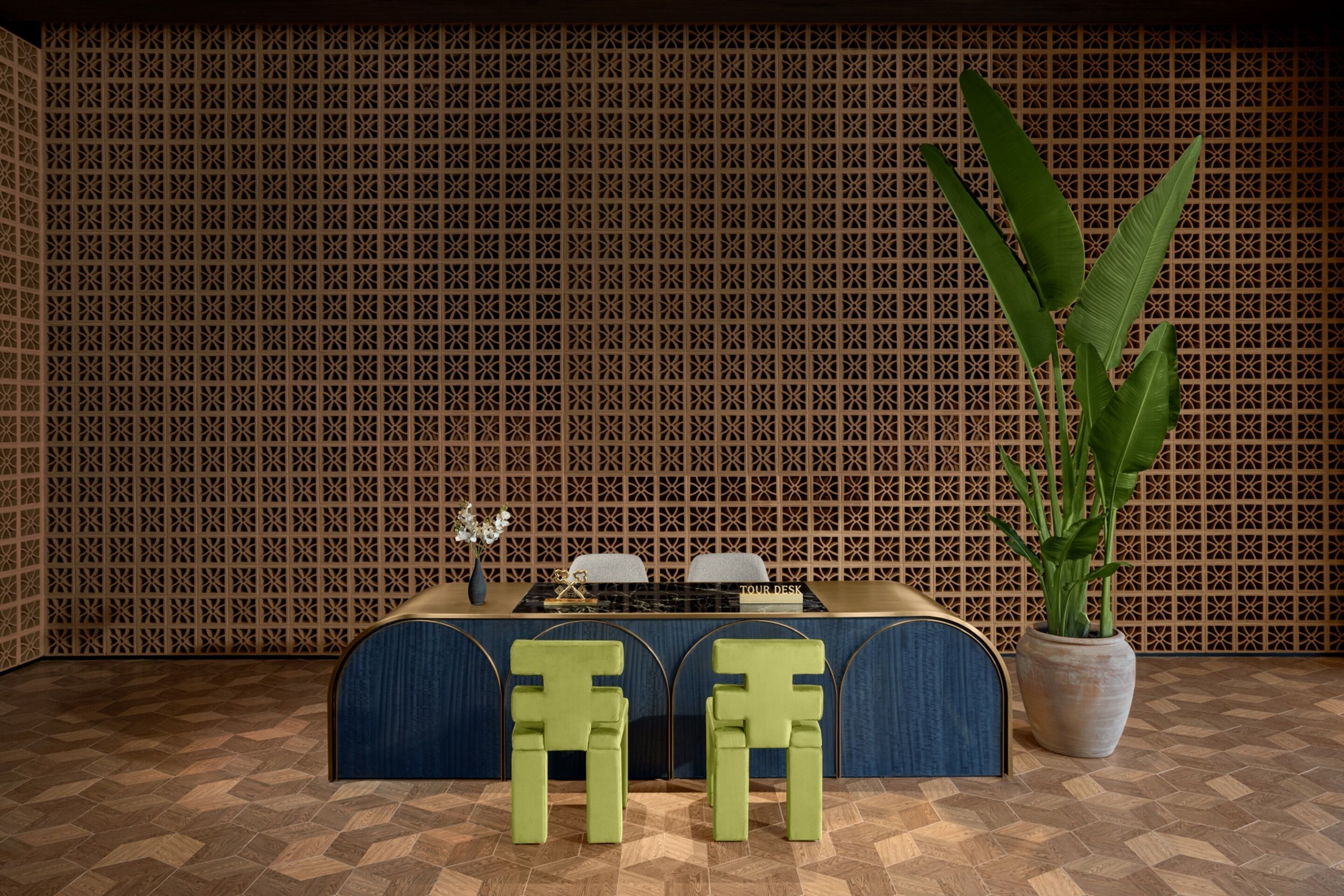Une pièce avec un mur décoré de motifs, une table avec des chaises et une plante en pot.