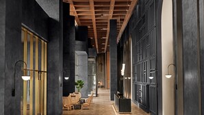 A modern interior with a wooden ceiling, dark walls, and a central seating area with a table and chairs. - L7 WEST LAKE HANOI By LOTTE HOTELS (Hanoi)