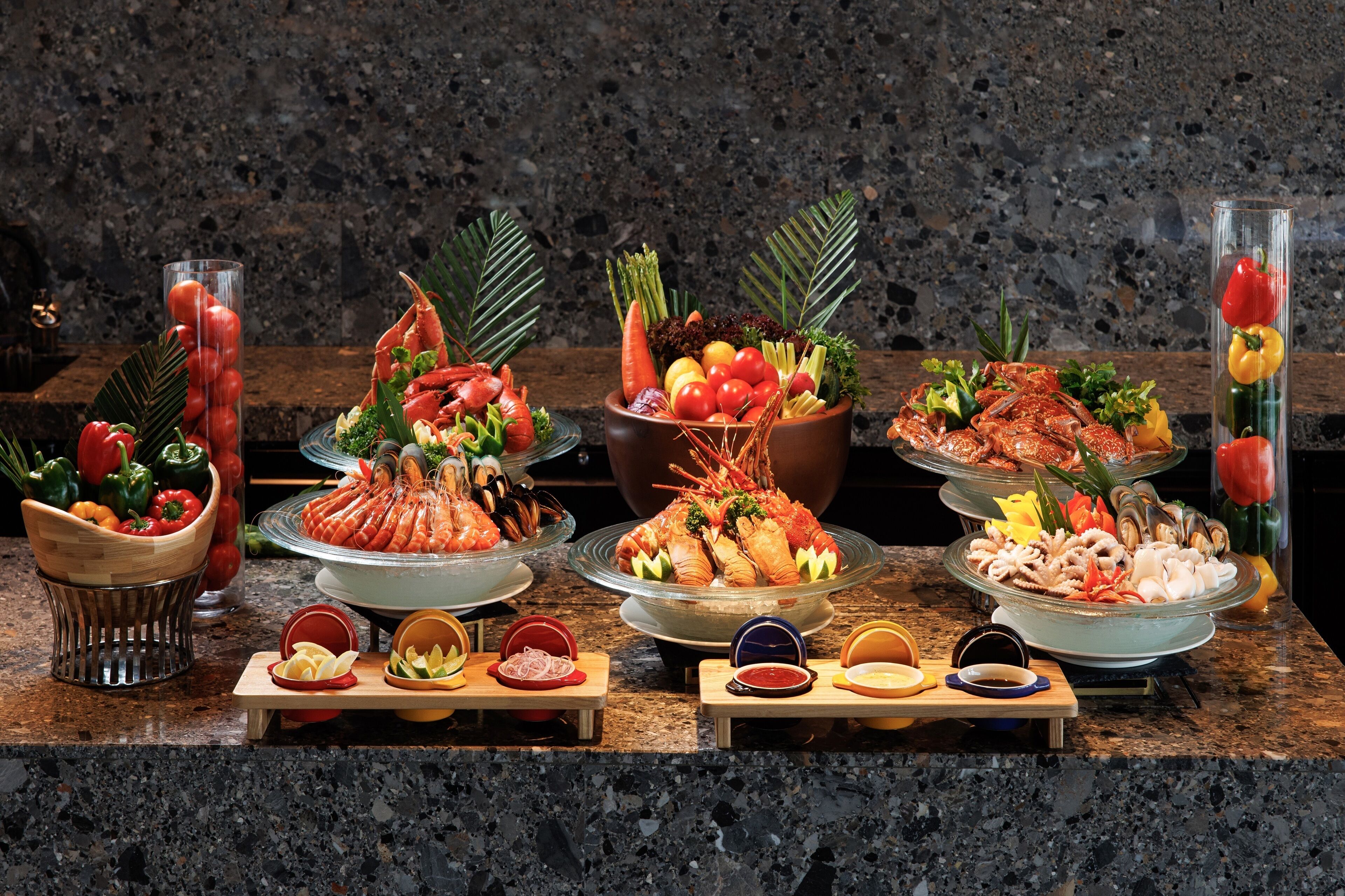 Un tavolo da buffet con diversi piatti di pesce, verdure e salse.