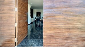 A modern interior with a wooden door leading to a dining area. - Gammarth Touristique Piscine Commune Bord de mer (La Marsa)