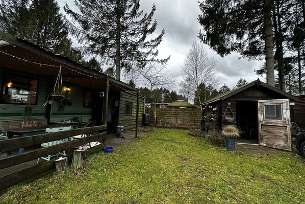 Relax in an outdoor space surrounded by trees and a well-maintained lawn.