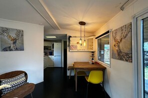 Enjoy meals in the kitchen with a central island and dining area, featuring an oven and wooden table.