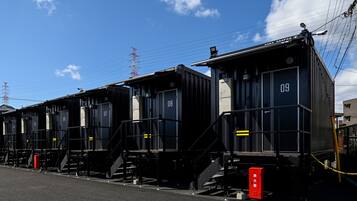 A row of black train carriages numbered 07 to 09, with steps leading up to the doors, and a red fire extinguisher visible on the right.