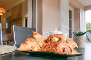 A table with croissants and a teapot.