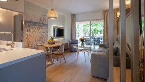 A modern living room with a dining area, a sofa, and a TV. - Rêves de Provence 1 renovated vacation apartment Sea and beach 150 m away (Gassin)