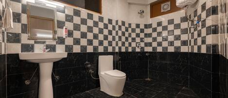 A bathroom with a checkered tile backsplash, a white sink, a toilet, and a shower area.
