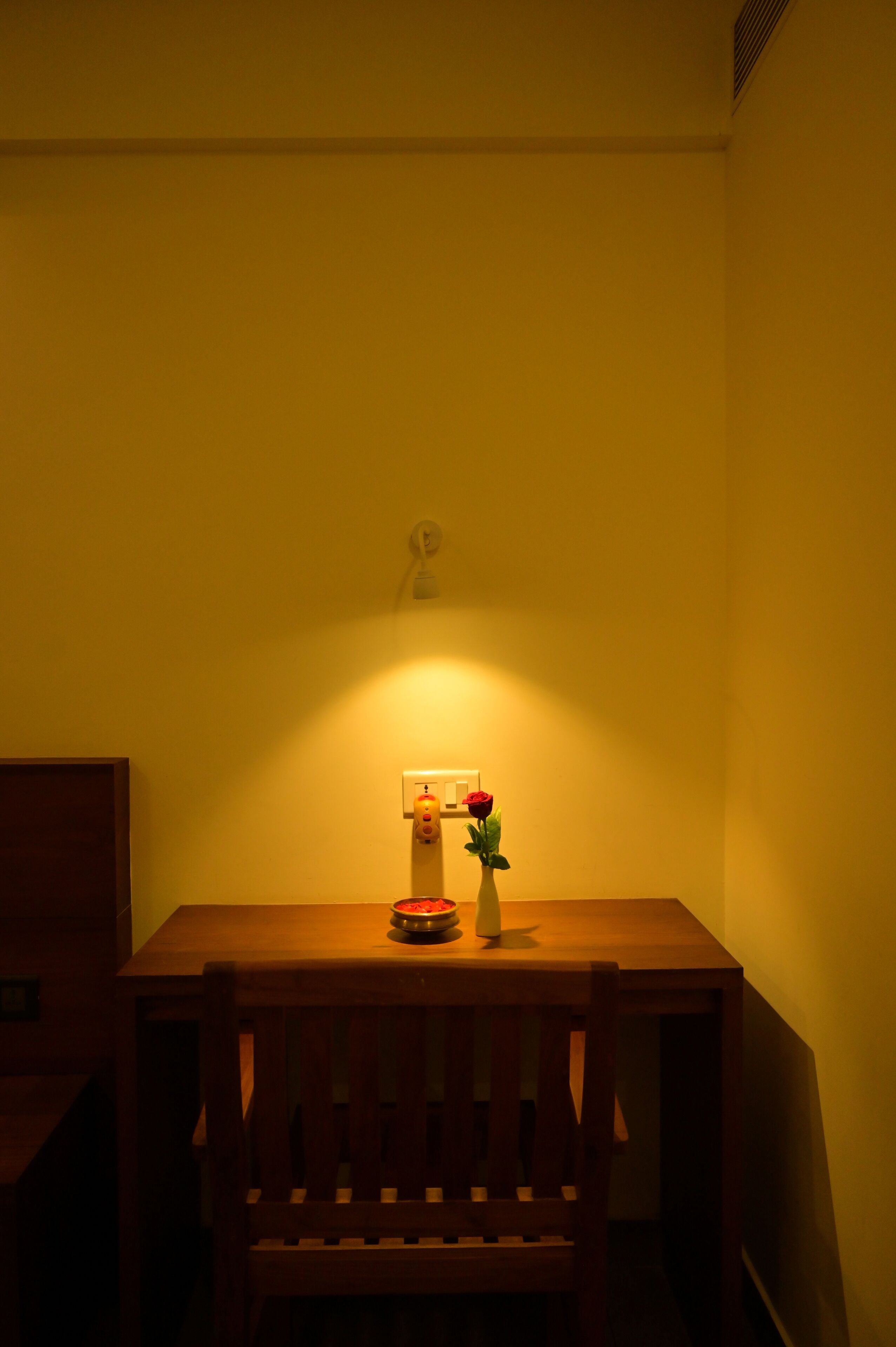 Una mesa de madera con un florero y un frutero.
