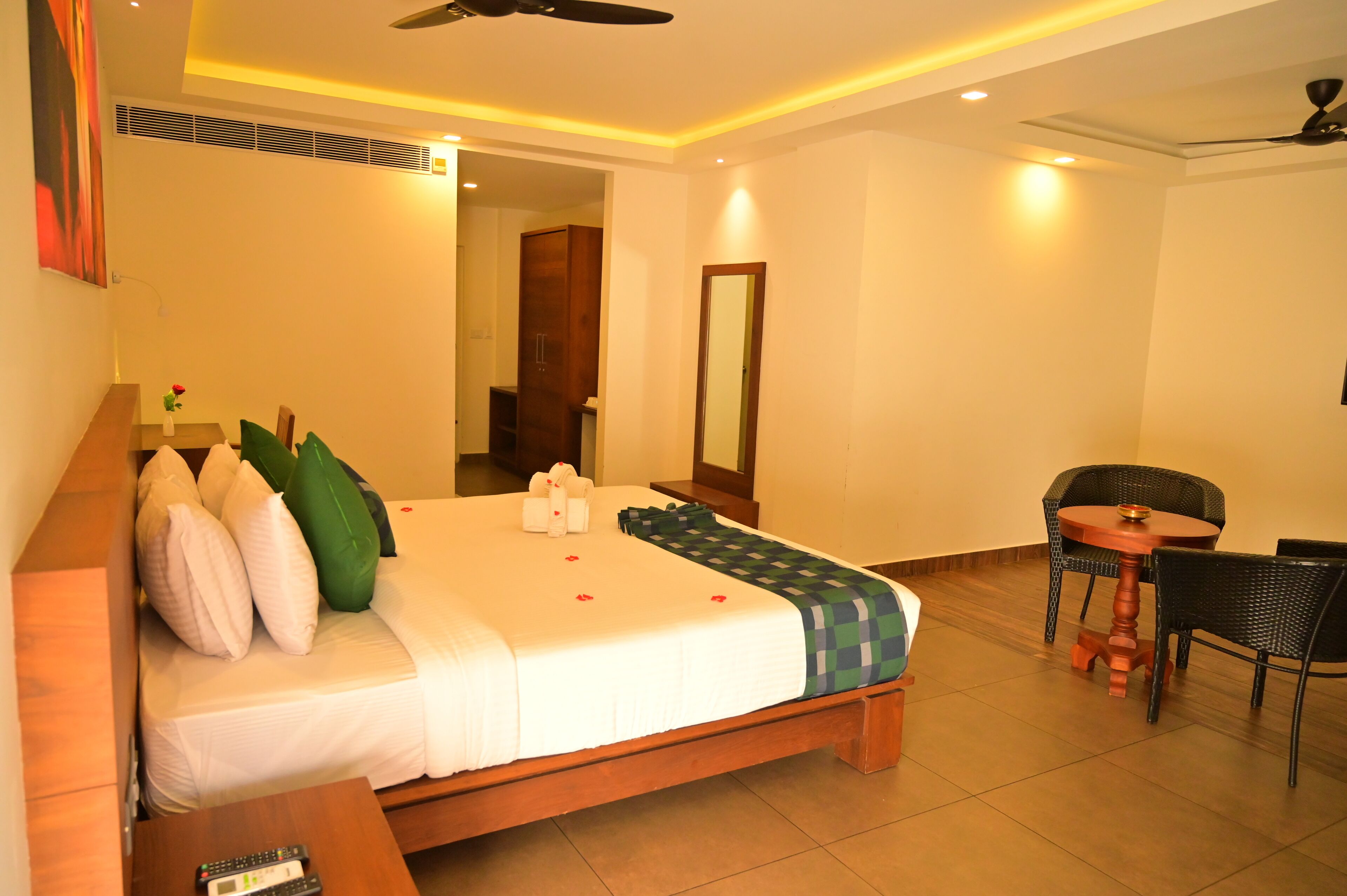 A hotel room with a bed, a small table, and a chair.