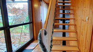 A wooden staircase with a white railing and a garland. - Peaceful house in the heart of Alsace (Baldenheim)