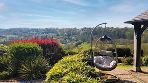 Una silla colgante en un jardín con vistas a un valle.