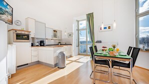 Eine moderne Küche mit weißen Schränken, einem Einbauofen und einer Kaffeemaschine.