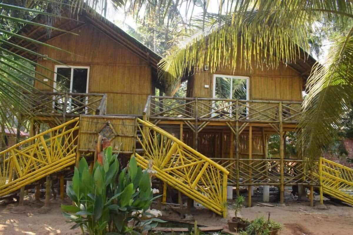 Una estructura de bambú con una escalera que lleva a una plataforma.