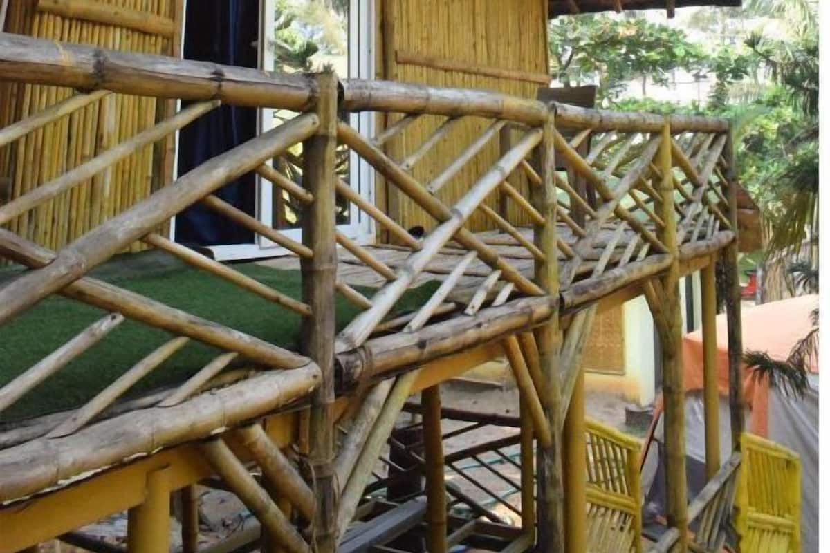 Una estructura de bambú con una escalera que lleva a una puerta.