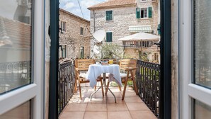 A balcony with a table and chairs, a satellite dish, and a view of traditional stone buildings. - Kotor Nest (Kotor)