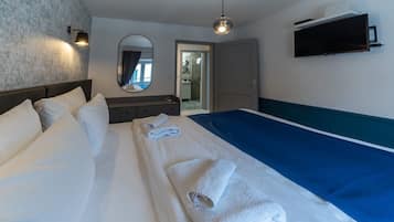Une chambre d’hôtel avec un lit, un bureau, un miroir et une télévision.
