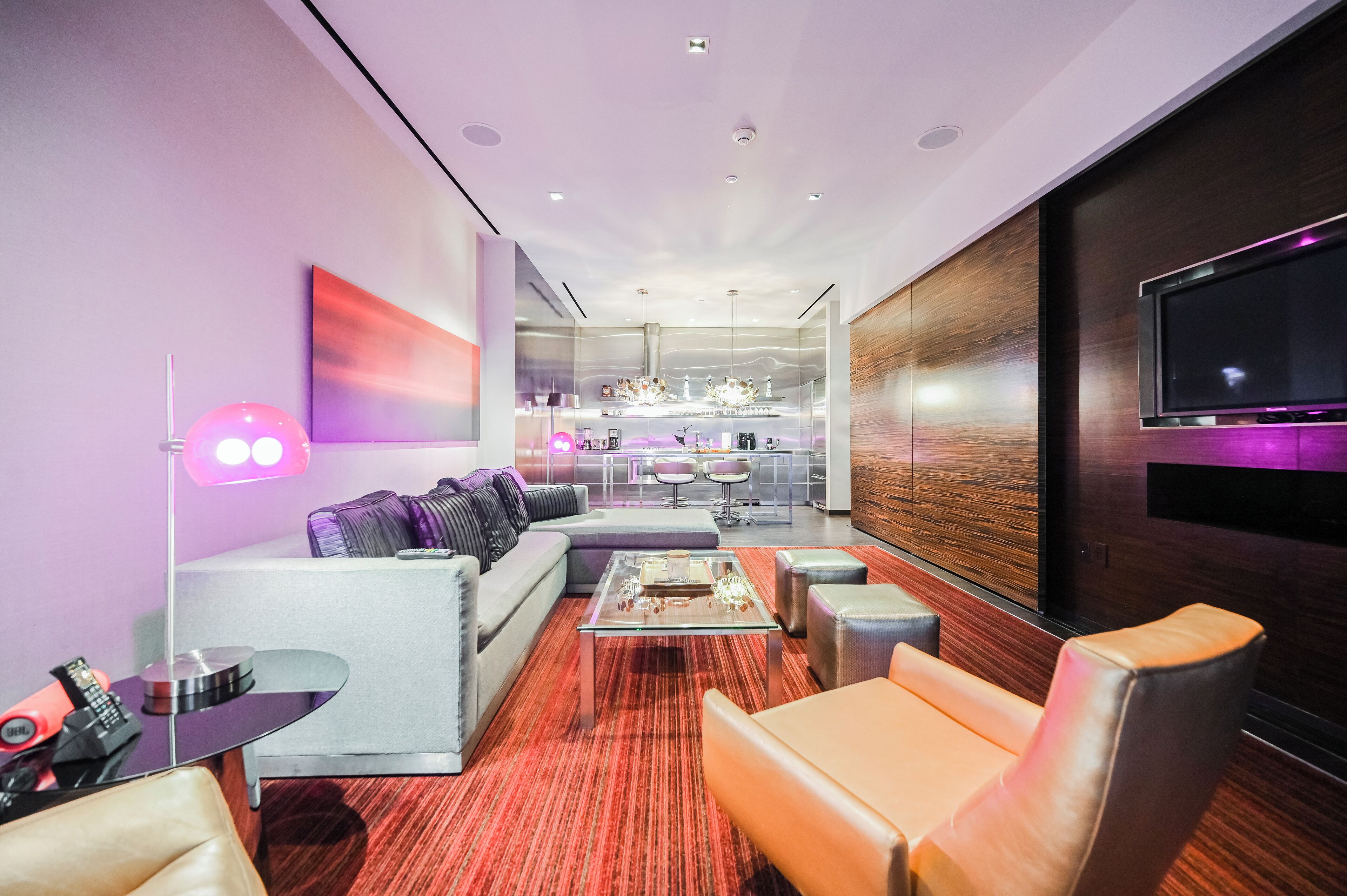 Un salon moderne avec un canapé, une table basse et un téléviseur fixé au mur.