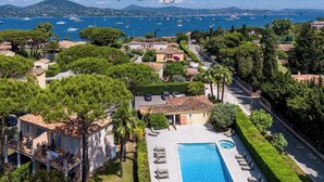 Propiedad residencial con piscina, vista al mar y montañas al fondo.