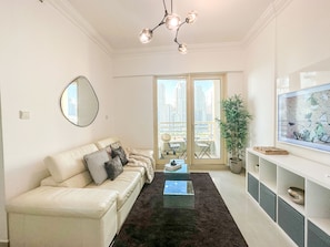 Relax in a stylish living space with a leather sofa, glass coffee table, and balcony views of the city.