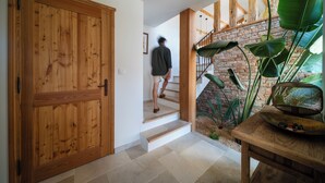 A wooden door, a staircase, and a table with a basket. - La maison de la Genette 5* Luxe -Sea view-Pool-1,5 km from the sea-12 persons (Cavalaire-sur-Mer)