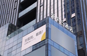 Placa de hotel com caracteres chineses e parte do nome em inglês.