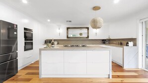 A modern kitchen with a central island, built-in appliances, and a pendant light. - Hollydale, Burradoo, Southern Highlands (Burradoo)