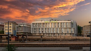 A modern building with a flat roof and multiple windows, located near a train station platform. - Apparthôtel Privilodges Toulon Centre Gare (Toulon)