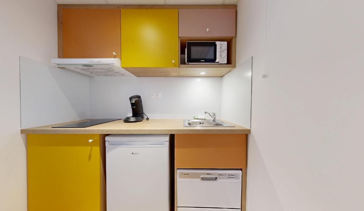 A compact kitchen with a microwave, coffee maker, and dishwasher.