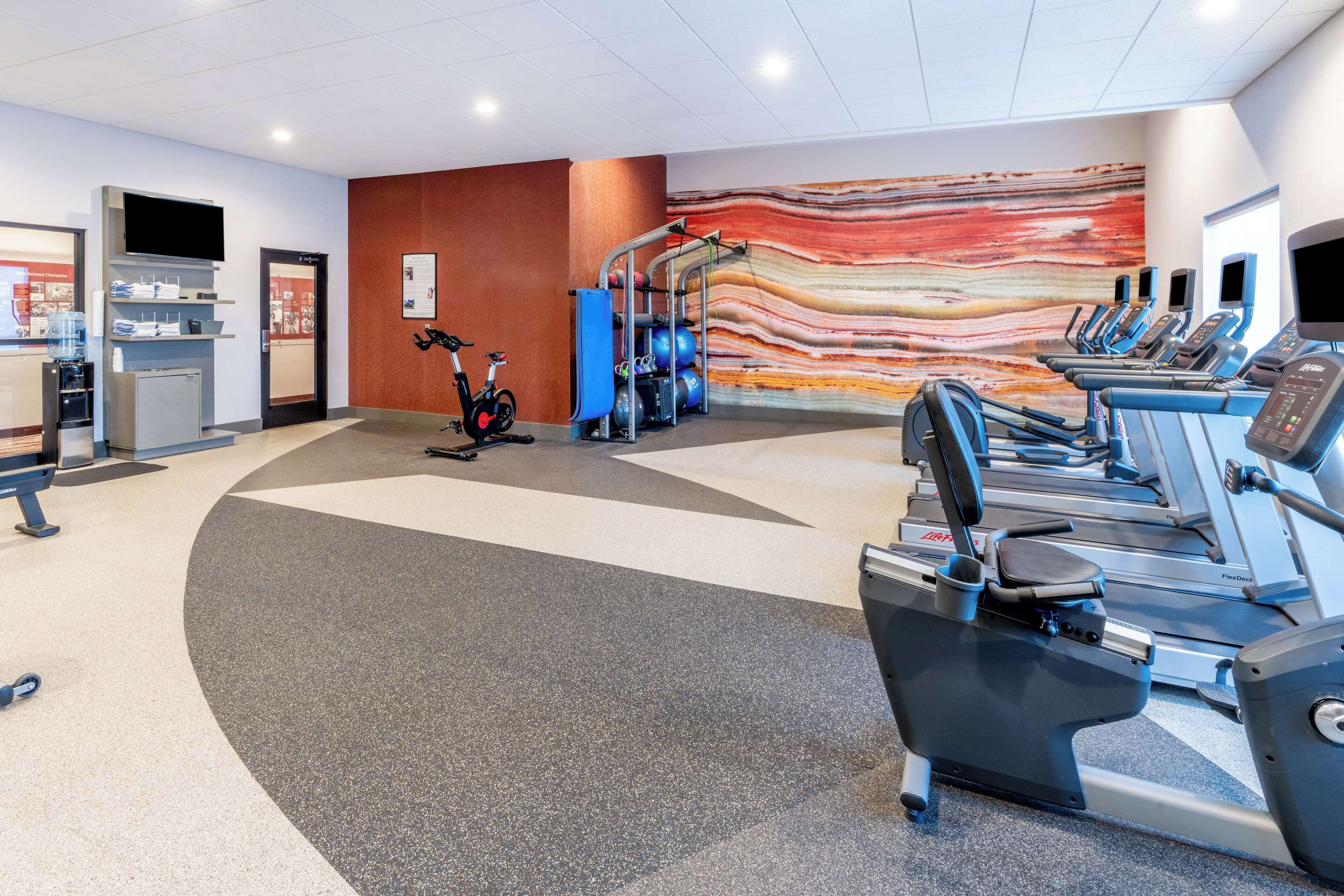 A gym with treadmills, an elliptical, and a stationary bike.