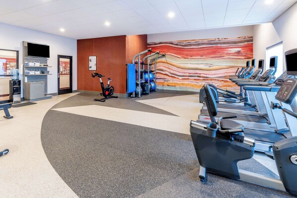 A gym with treadmills, an elliptical, and a stationary bike. - Hilton Garden Inn Trinidad Downtown (Trinidad)