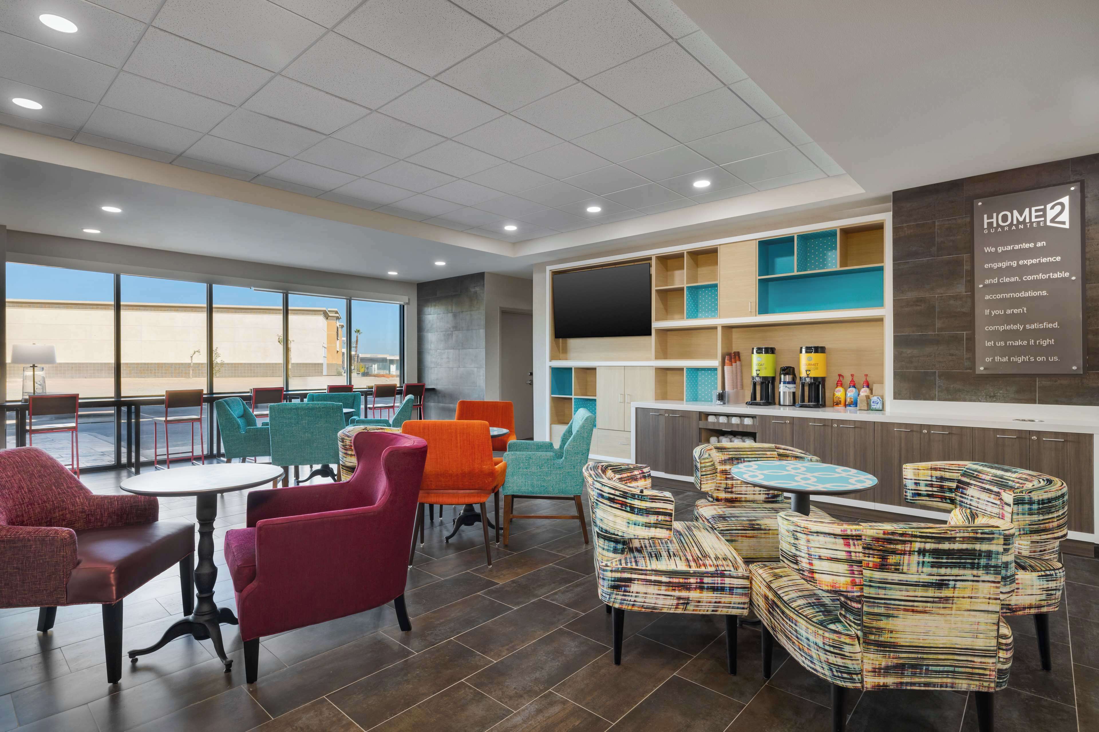 A hotel lobby with a bar area, seating arrangements, and a large window offering a view.