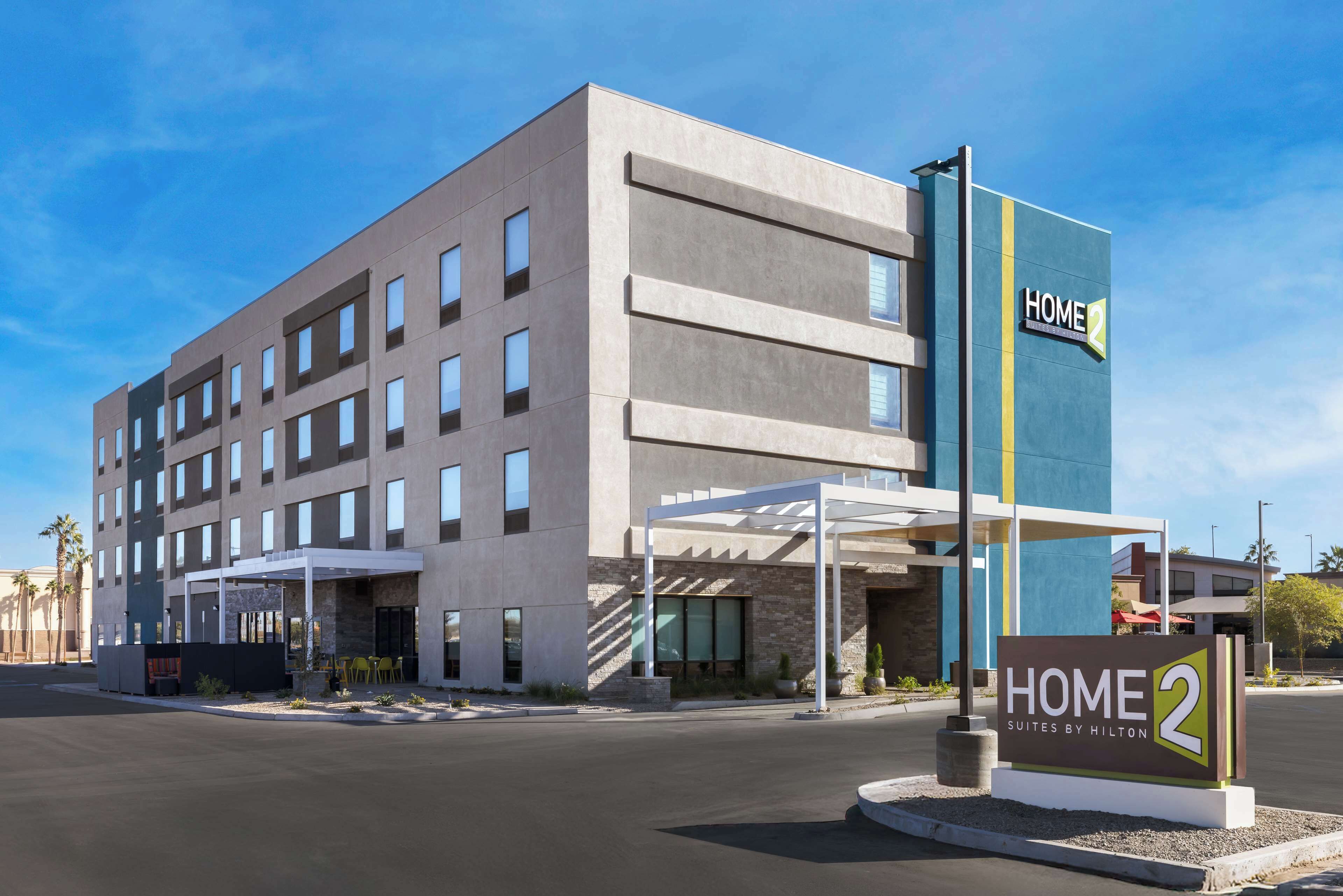 A modern hotel with a sign reading "HOME 2 Suites by Hilton".