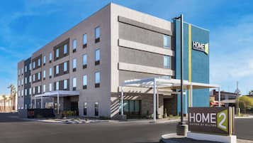A modern hotel with a sign reading "HOME 2 Suites by Hilton".
