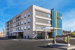Un hotel moderno con un letrero que dice 'HOME 2 Suites by Hilton'.