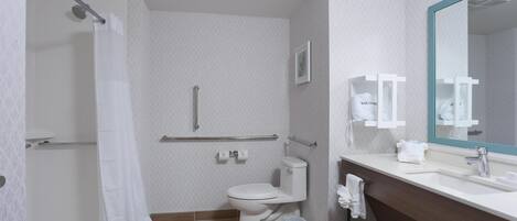 A modern bathroom with a shower, toilet, and sink.