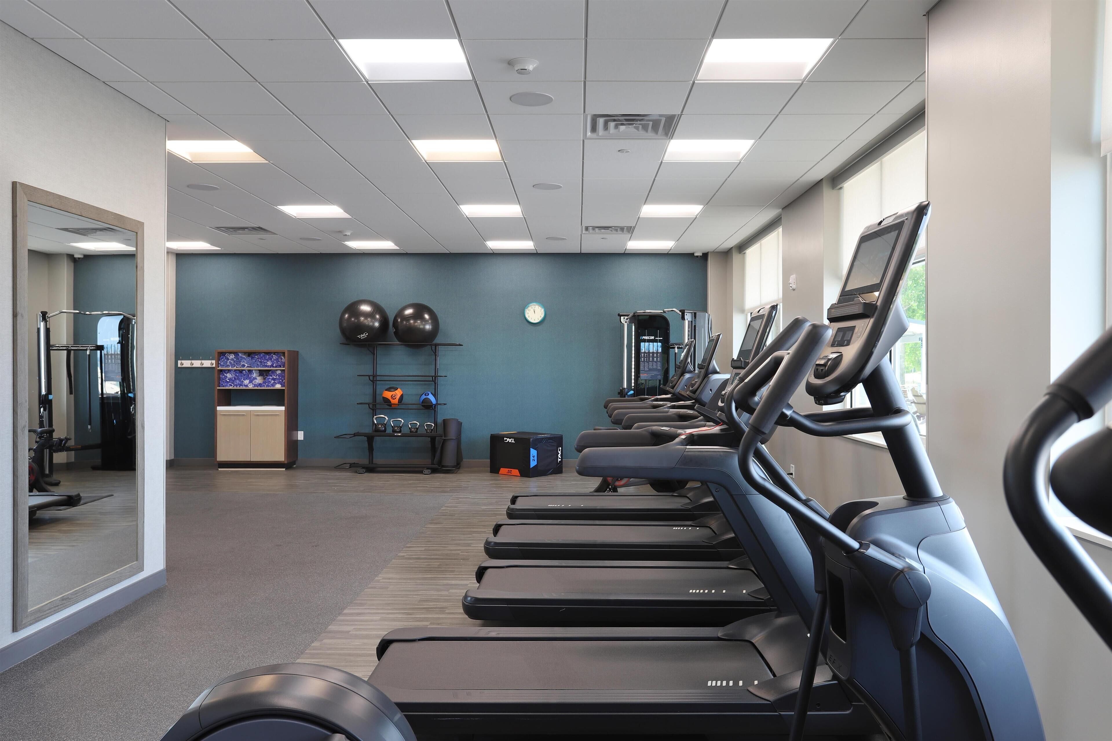 A gym with treadmills, exercise balls, and a weight bench.