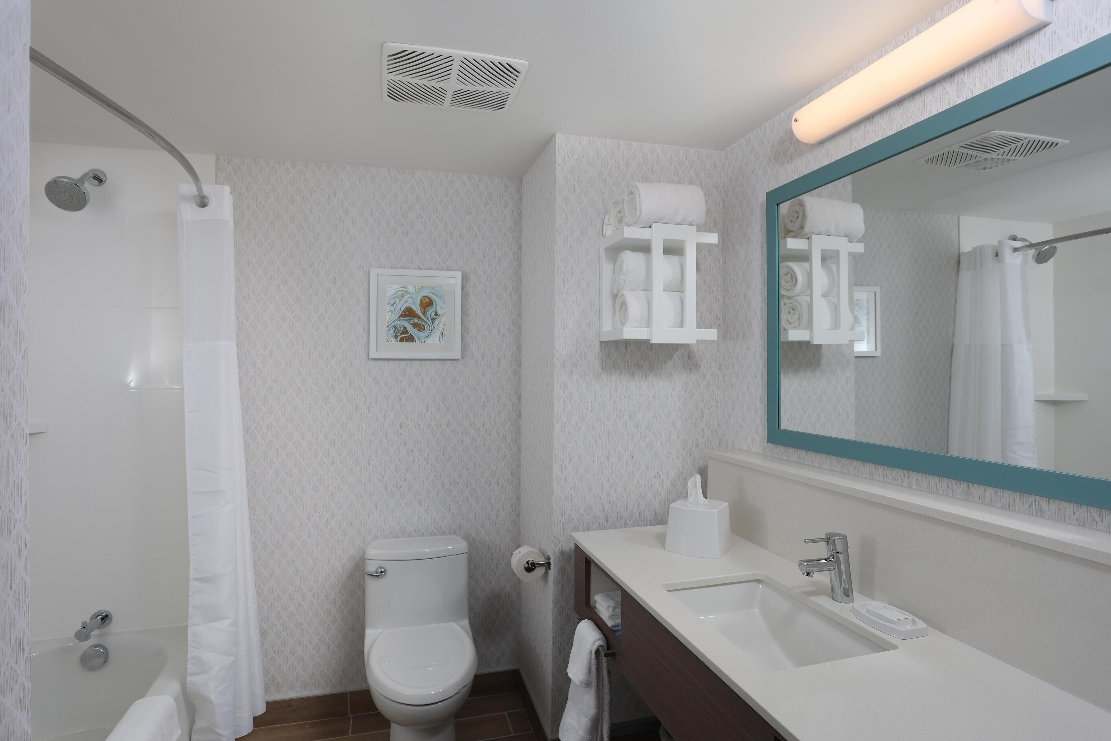 Une salle de bain moderne équipée de toilettes, d’un lavabo et d’une douche.