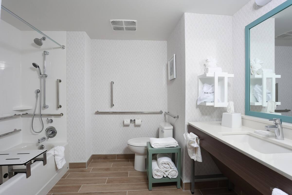 A modern bathroom with a shower, toilet, and sink.